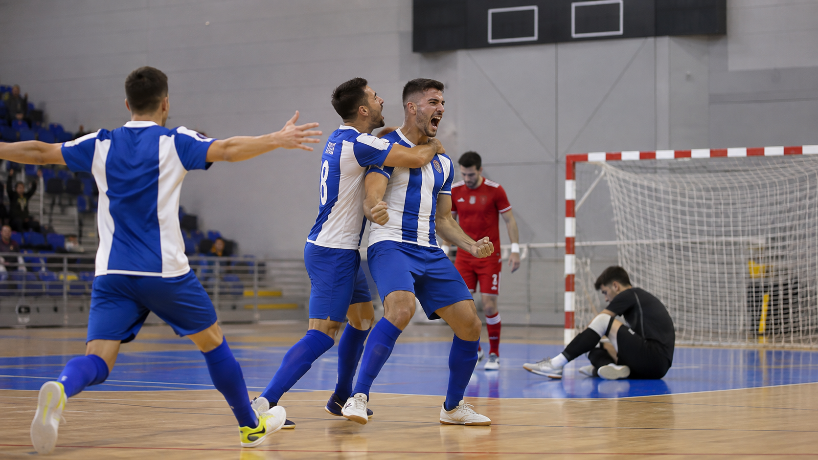 Recreación generada con IA de varios jugadores de fútbol sala celebrando un gol en un pabellón
