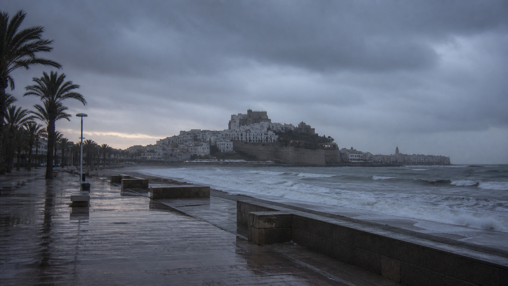 Recreación generada con IA de nubes de tormenta y lluvia sobre el paseo marítimo de Peñíscola
