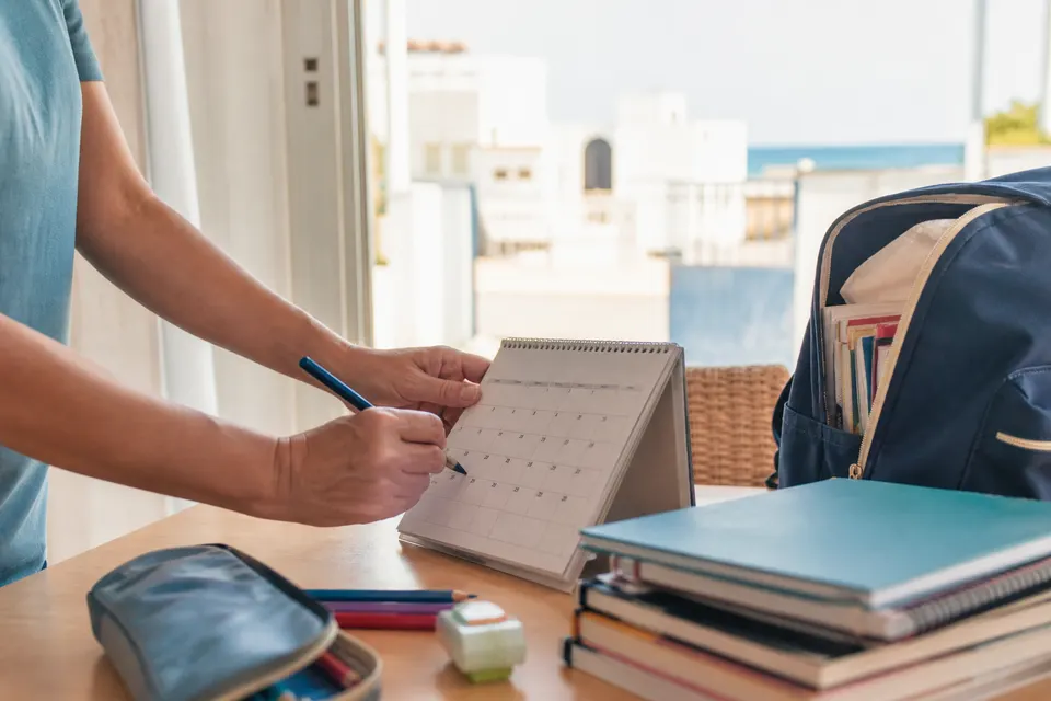 Recreación generada con IA de una familia preparando el calendario y el material para la vuelta al colegio en Peñíscola